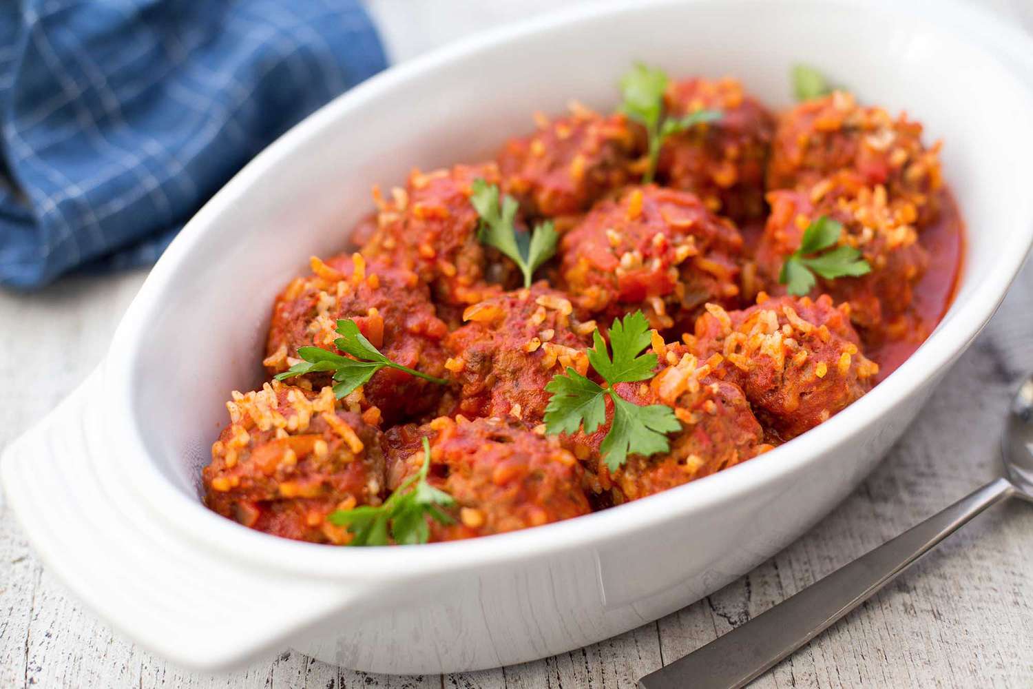 Meatballs with rice in a white dish.