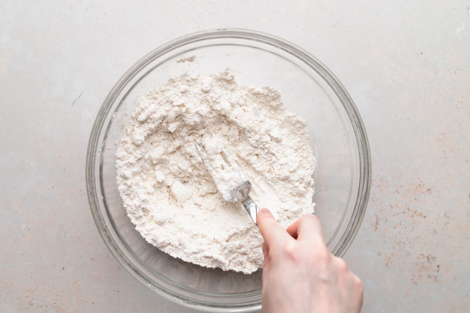 Making biscuits in a glass bowl for a biscuits and gravy recipe.