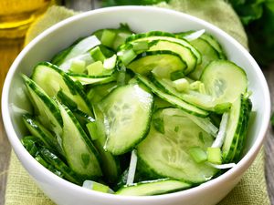 A bowl filled with freshly sliced cucumbers and onions for a salad