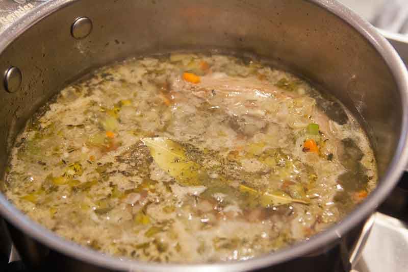 Giblets boiling with chopped vegetables and herbs 