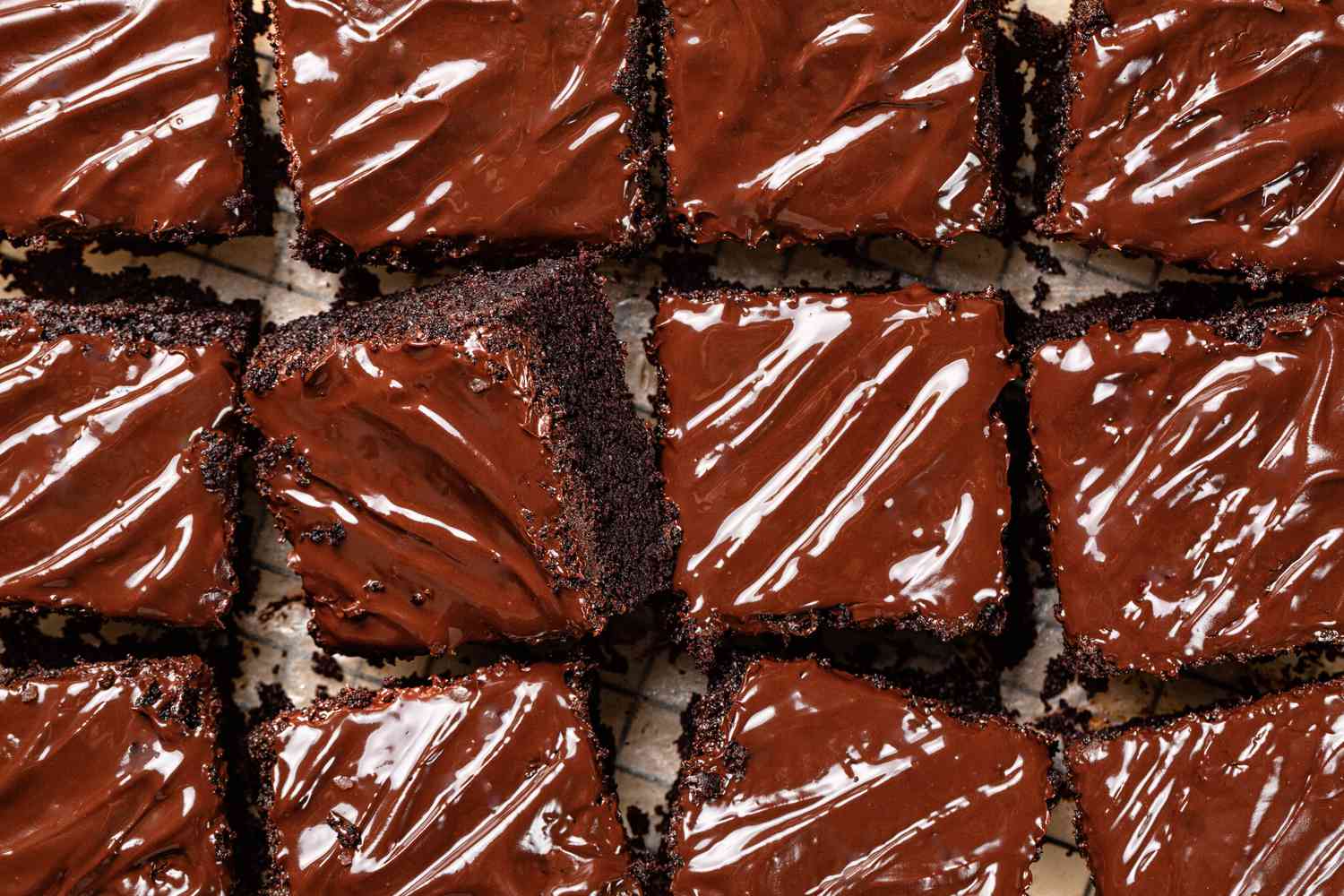 Slices of chocolate cake topped with shiny chocolate frosting