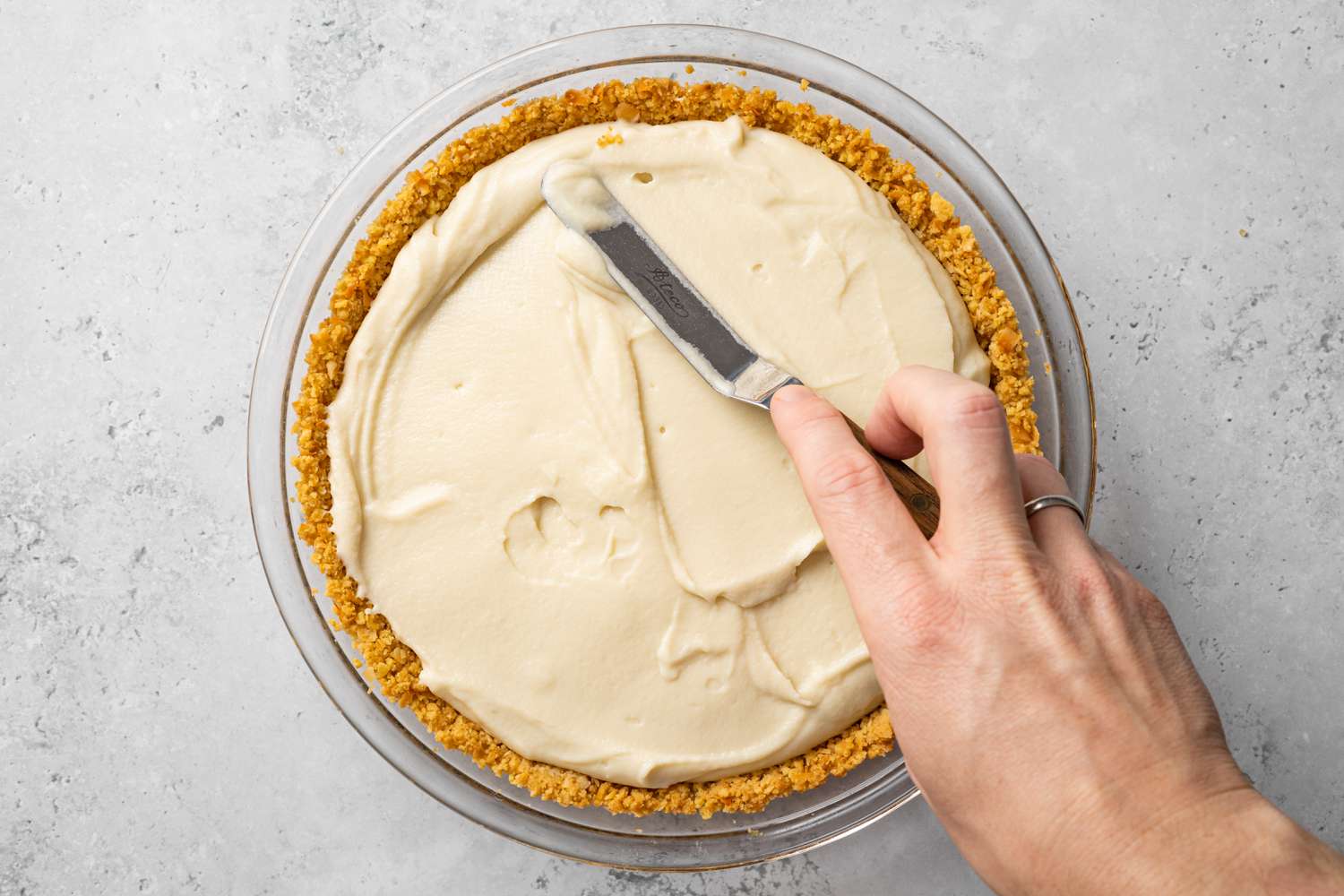 Piña Colada Pie Cream Added to Pie Crust and Smoothed Out Using an Offset Spatula