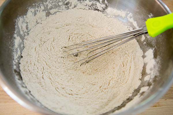 whisking together ingredients for chocolate chunk cookies