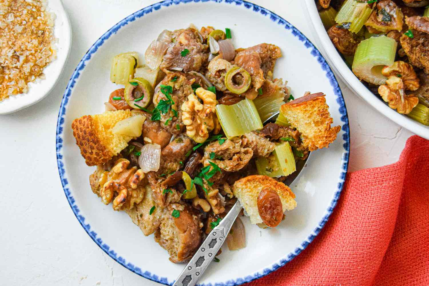 A serving of stuffing on a white plate wiht blue edges
