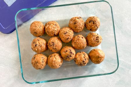 Overhead view of 5-ingredient energy balls in a clear glass bowl on marble counter