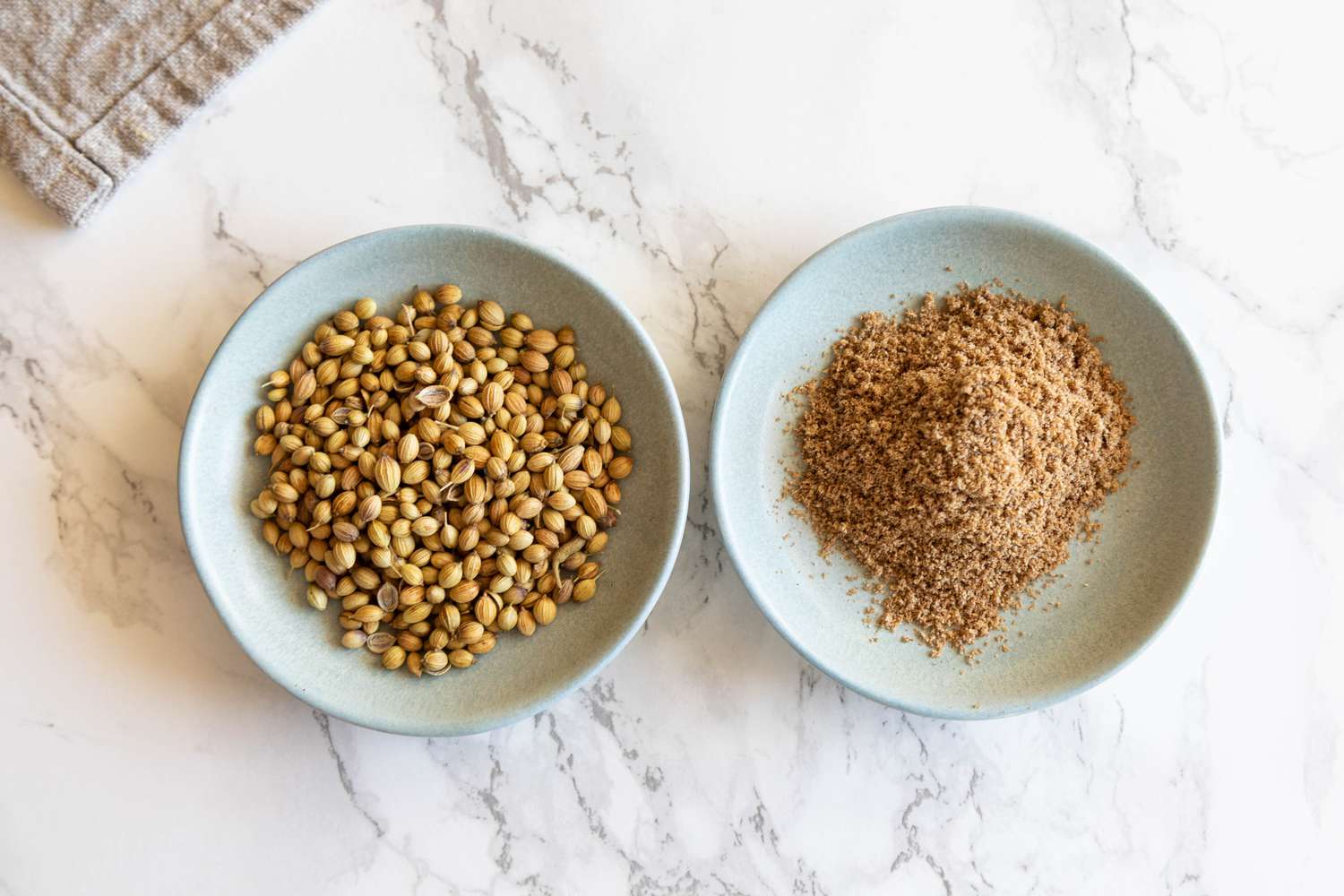 Two bowls of coriander one ground and one whole pod