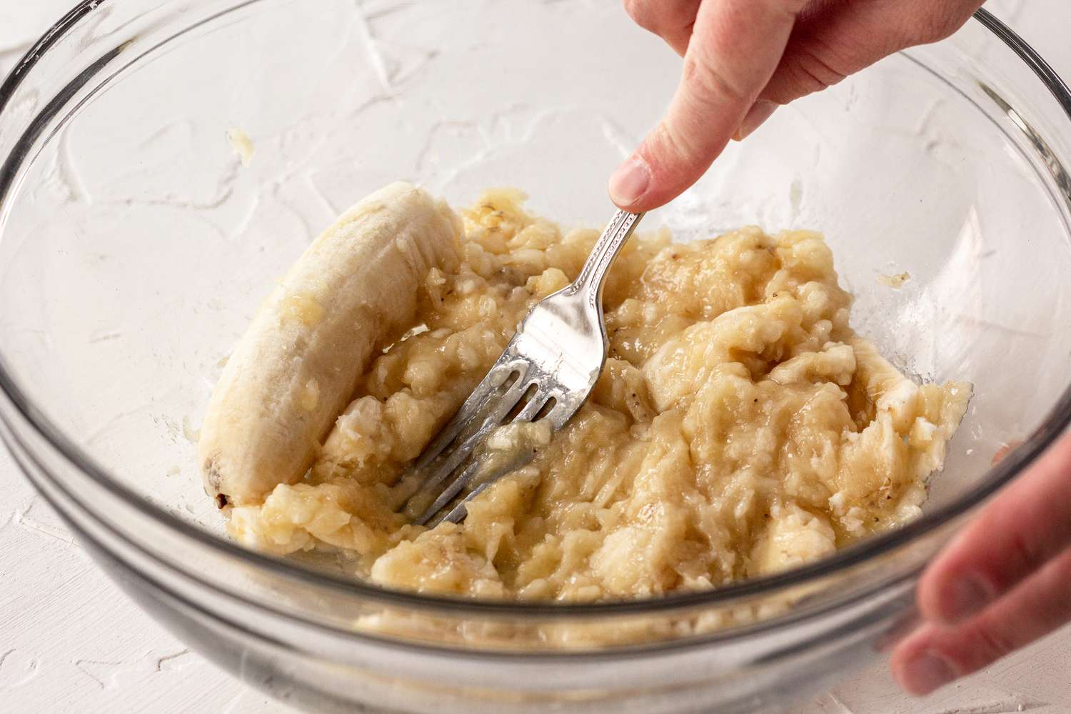 Smashing bananas to make banana bread.