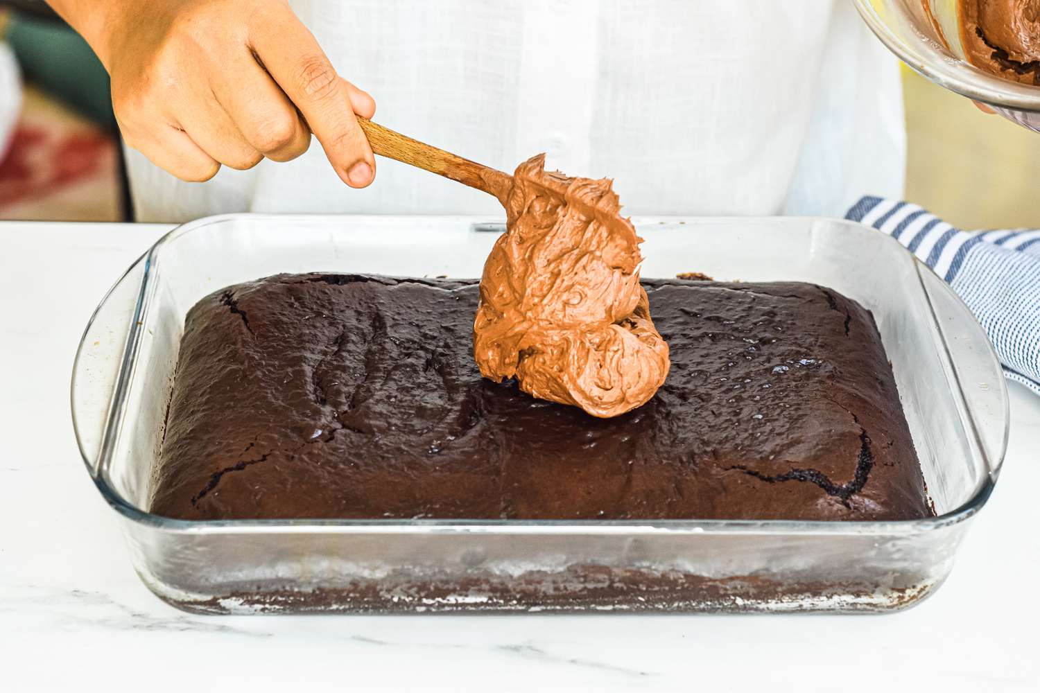 Chocolate Buttercream Spooned onto Sheet Cake in the Baking Pan