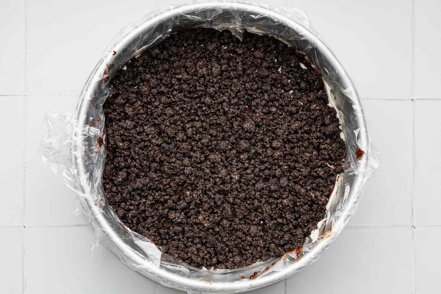 Assembling the Oreo Ice Cream Cake (Rest of the Layers): Crunchies Added to Cake Pan After the Hot Fudge Layer