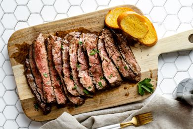 Overhead view of a flank steak sliced on a cutting board.