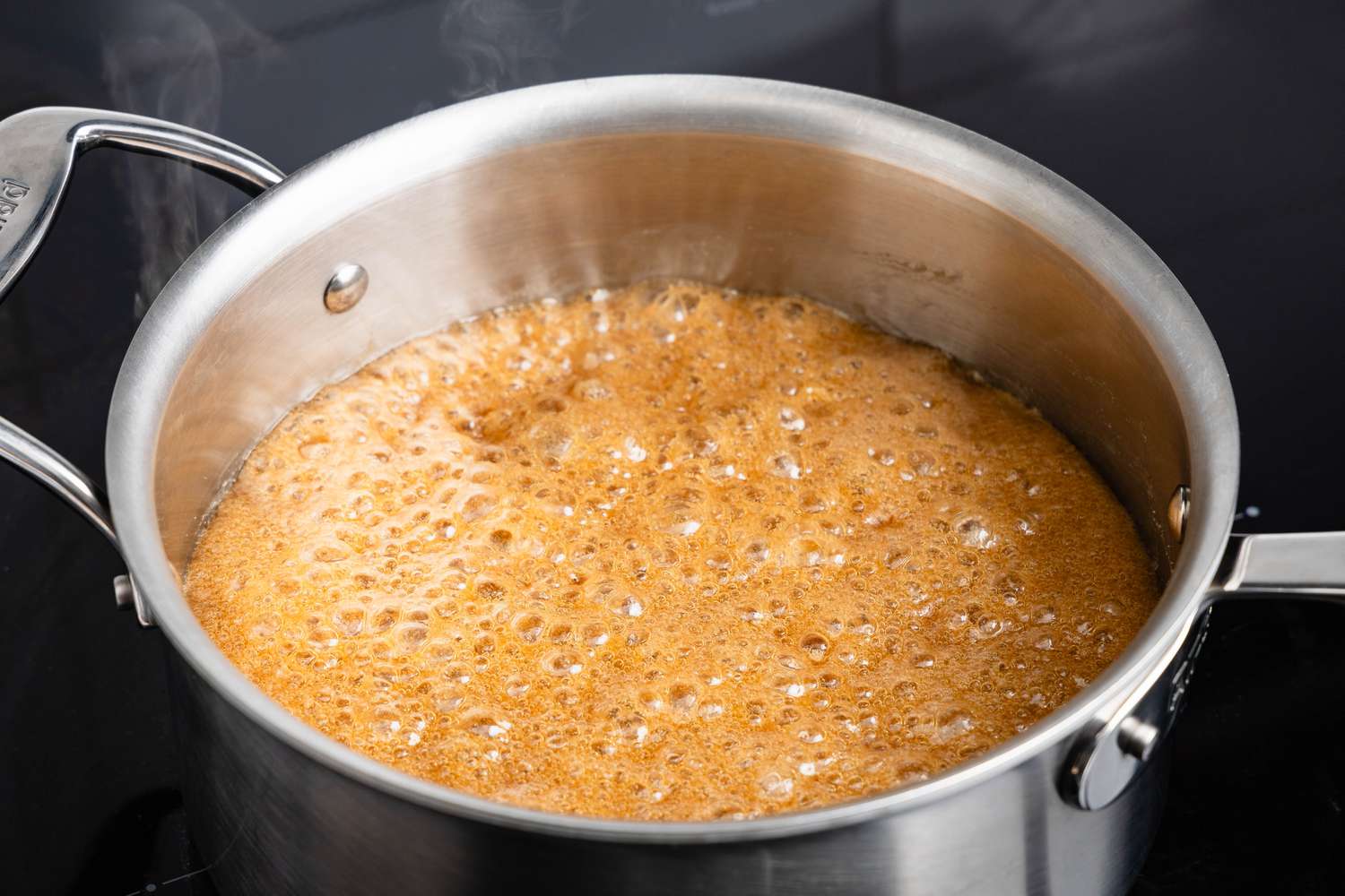Penuche boiling in a sauce pan over a stove
