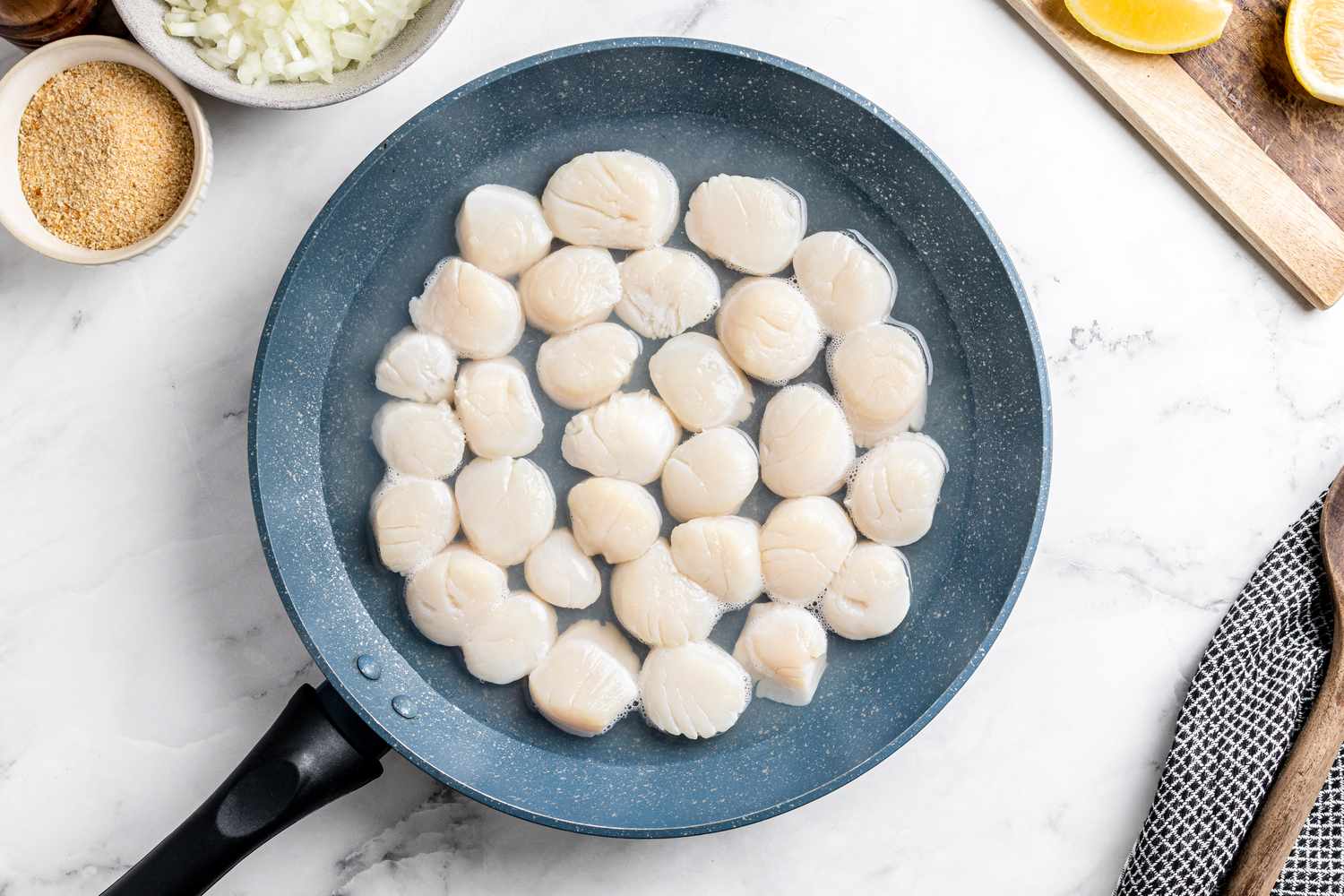 Raw scallops in a skillet
