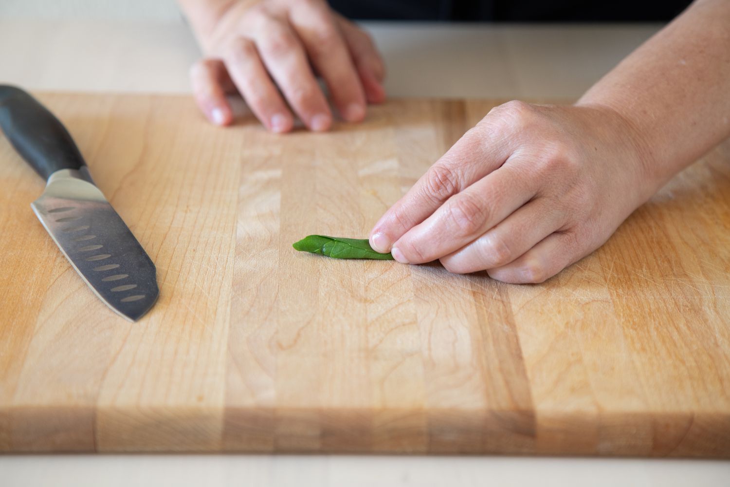Basil leaves rolled up into a tube for chopping