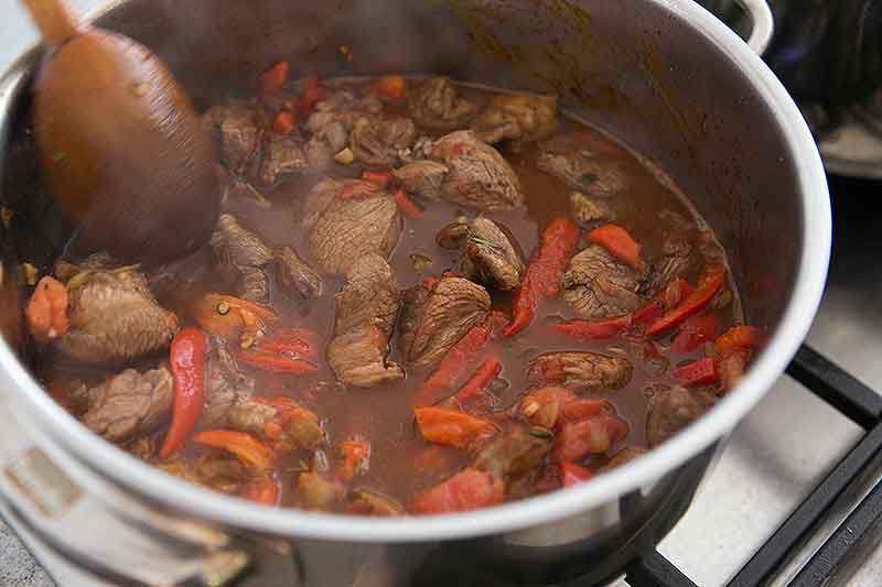 Lamb stew cooking on stovetop in pan