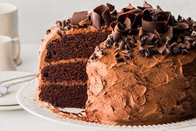 Triple layered chocolate cake topped with a slice missing