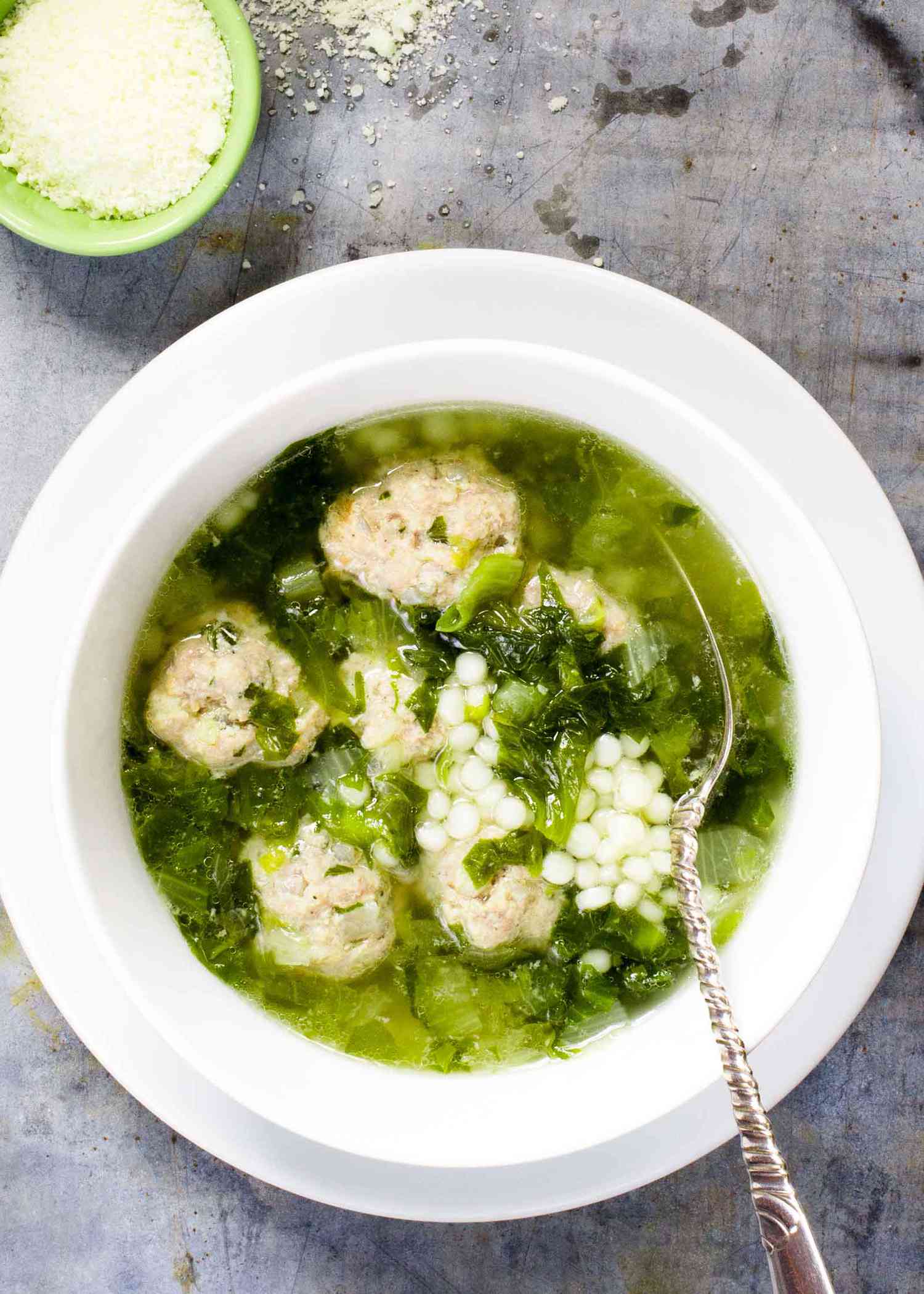 Italian wedding soup with meatballs in a white bowl
