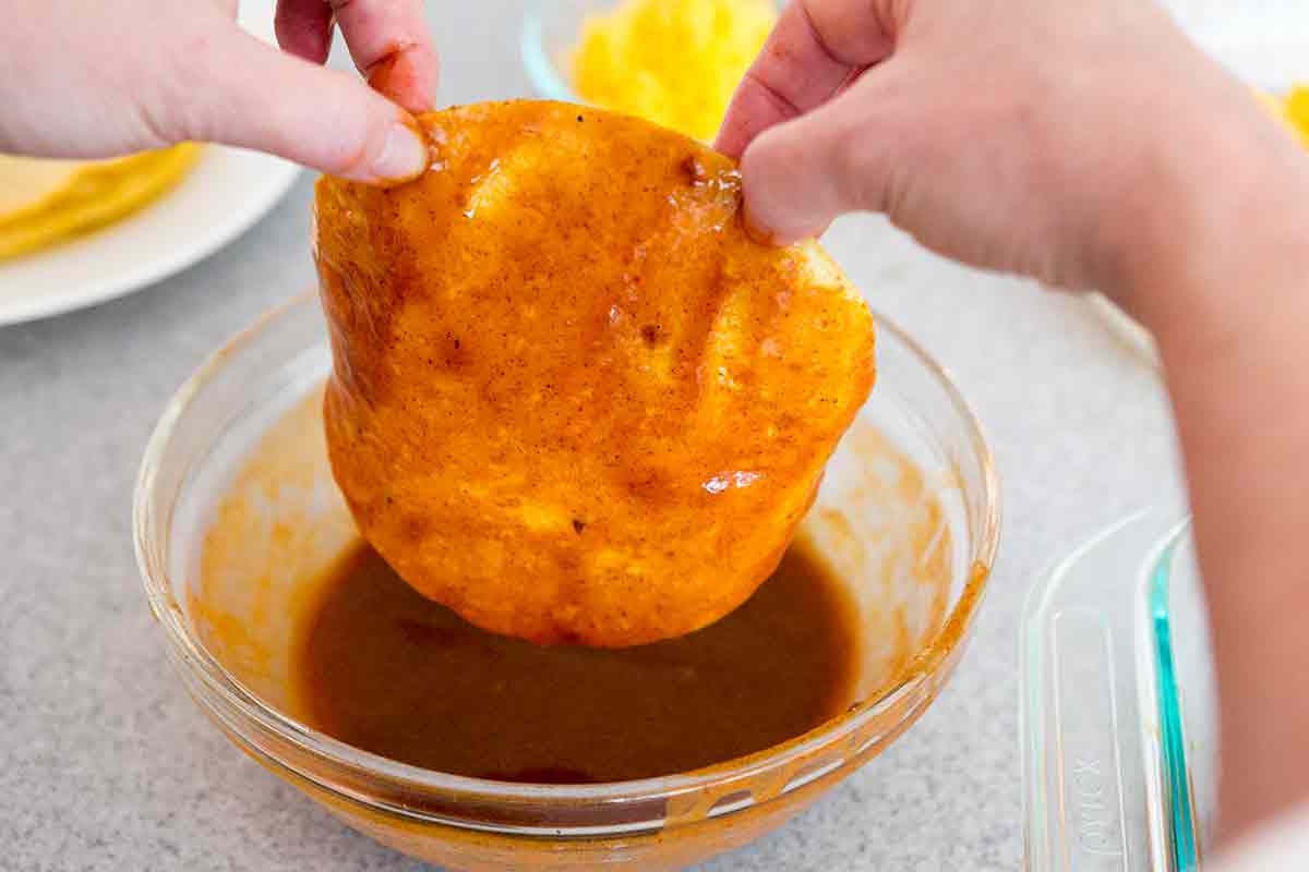 dip tortillas in red chili enchilada sauce for chicken enchiladas