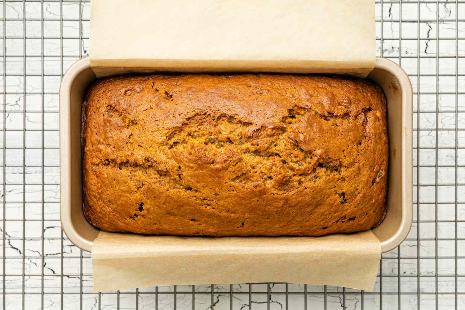 Baked Dark and Stormy Banana Bread in the Loaf Pan on a Cooling Rack