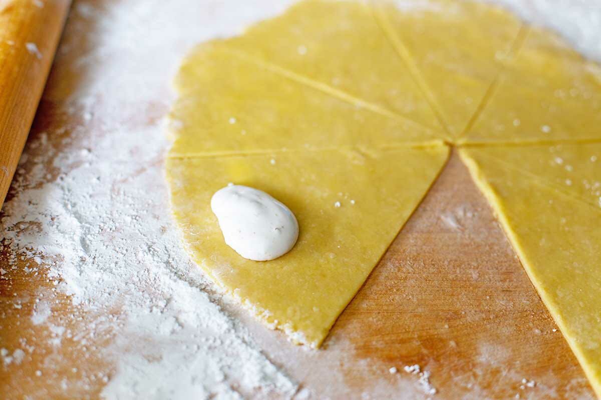 Filling set inside a triangle of dough to make Hungarian Butter Horns.