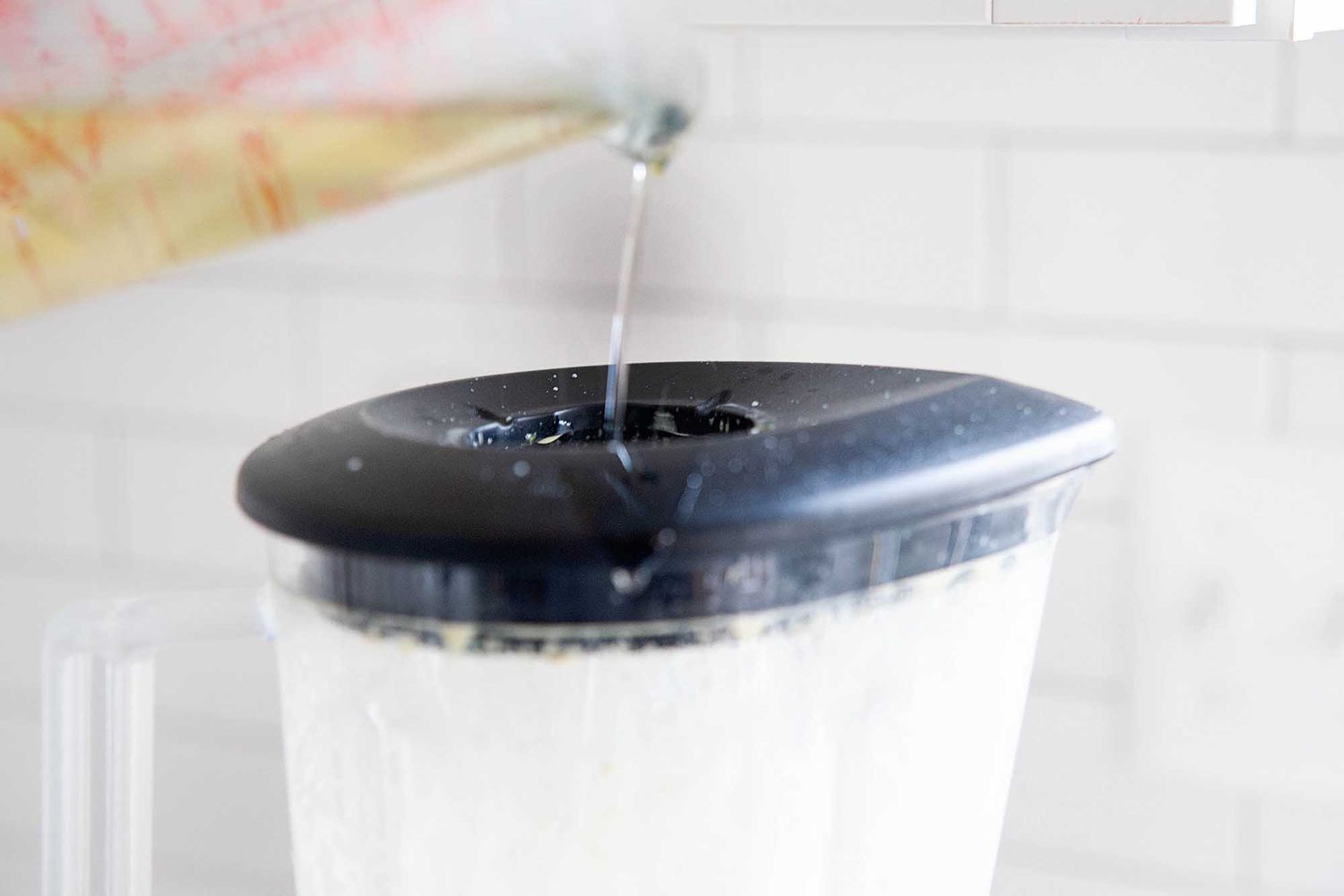 Pour the oil slowly into a blender to make homemade mayonnaise