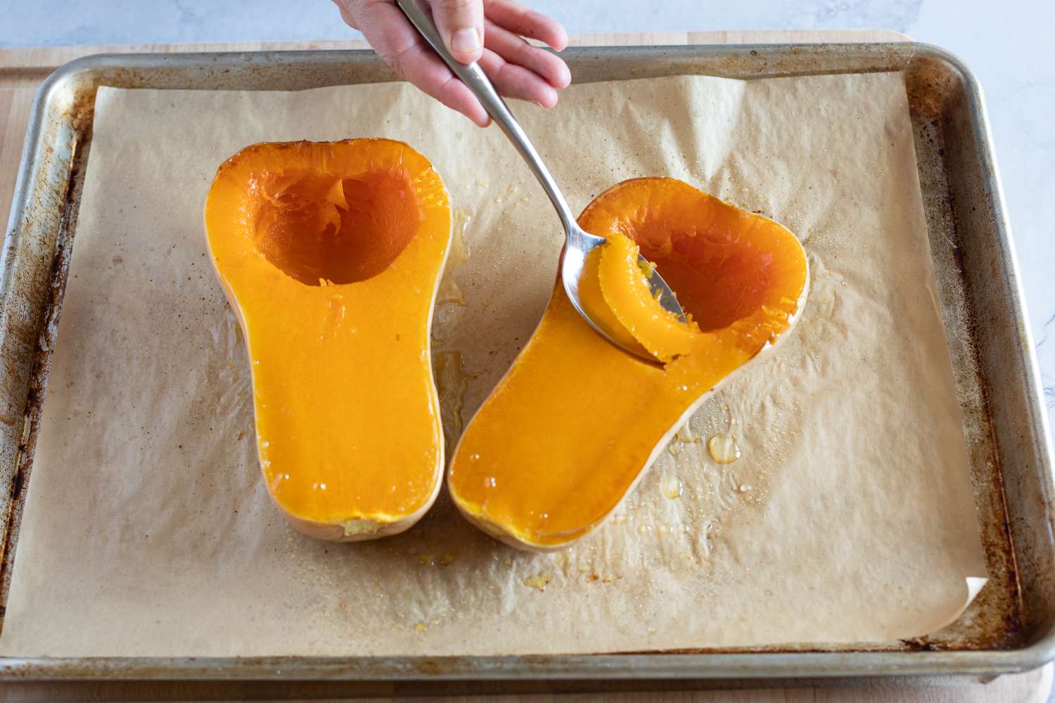 Scoop out cooked butternut squash with a spoon