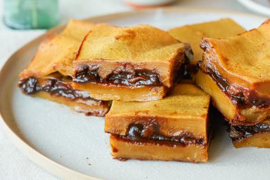 Side view of red bean paste rice cake stacked on a plate.