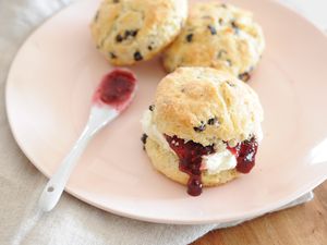 Traditional Irish Scones on a plate and spread with jam.