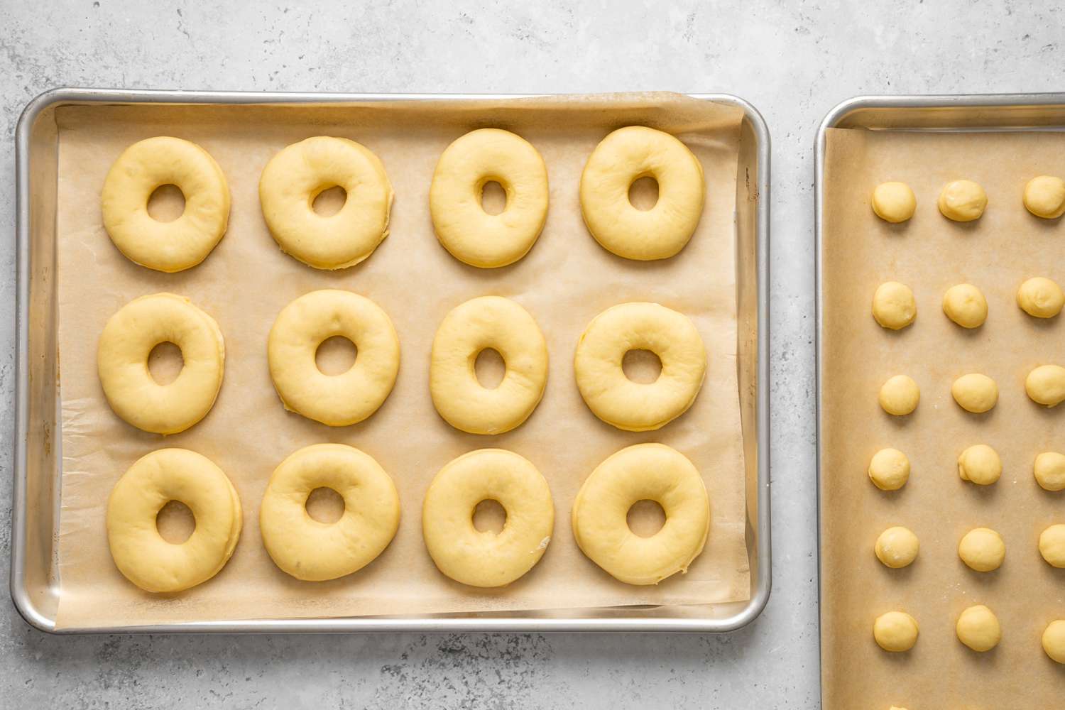 Proofed Donuts and Donut Holes on Two Lined Baking Pans