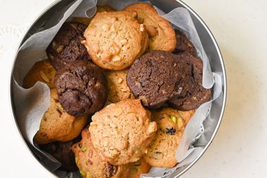 An assortment of cookies in a round tin box