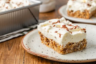 Slice of ritz torte on a plate, and in the background, a baking pan with more and a plate with another slice