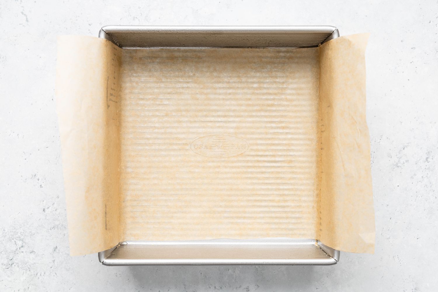 Baking pan lined with parchment paper for penuche recipe