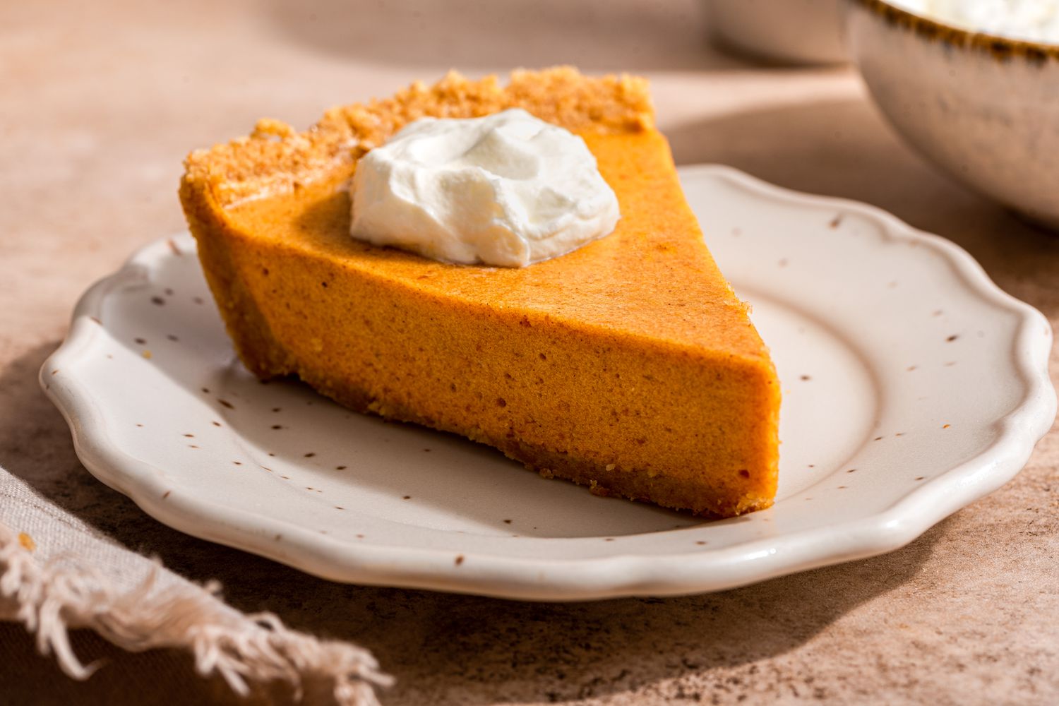 Slice of no-bake pumpkin pie topped with whipped cream