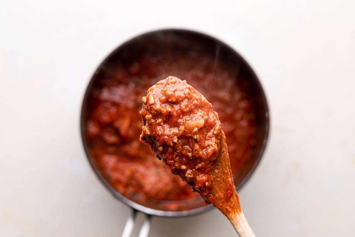 Lifting the meat sauce out of the pot for an easy lasagna recipe.