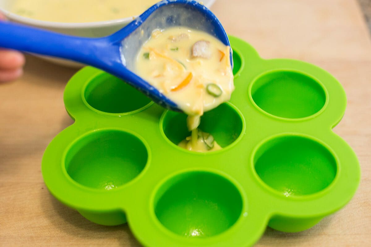 Spoon the egg filling for the copycat starbucks egg bites into each of the wells of the silicon