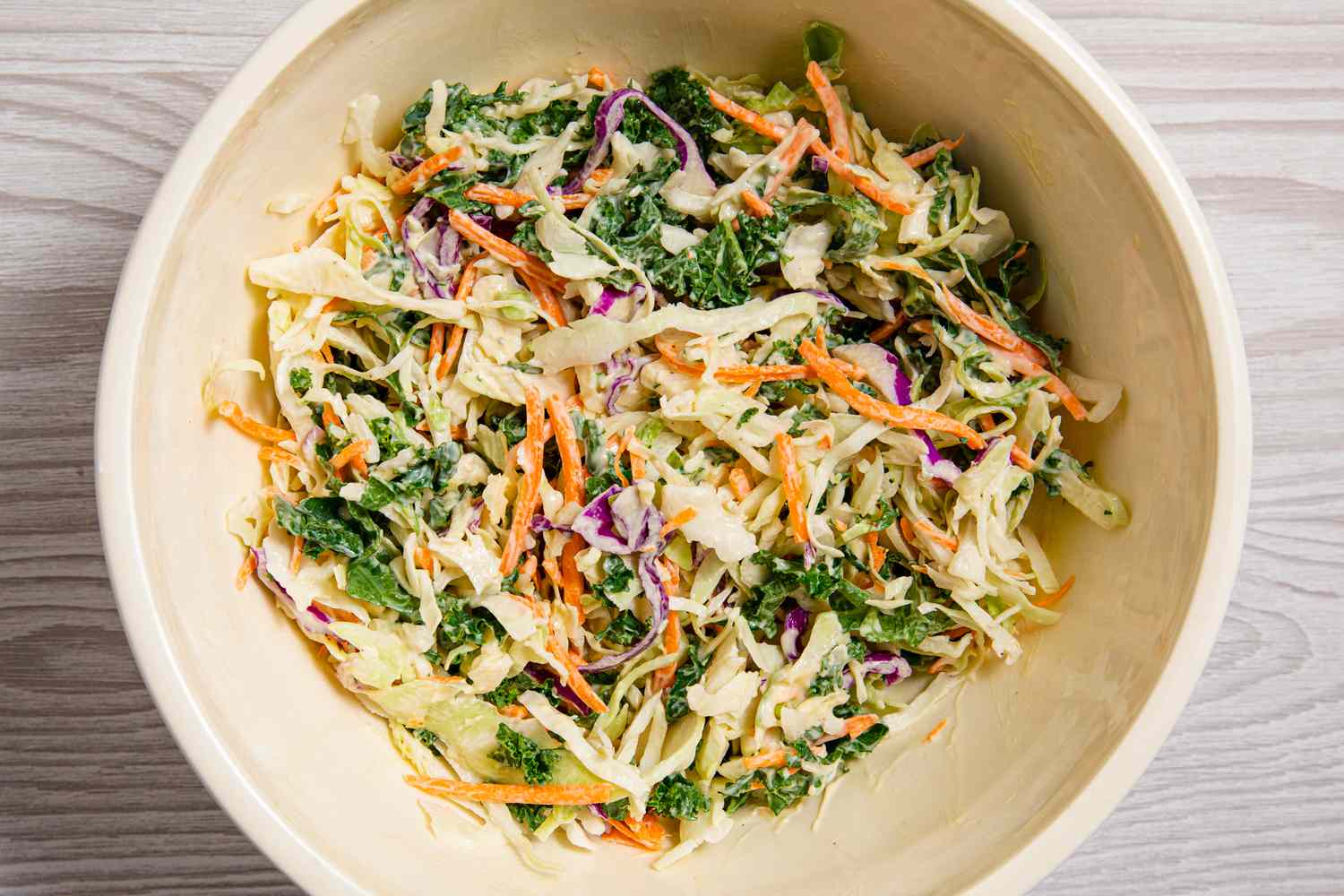 A large bowl of coleslaw made with shredded vegetables, including cabbage and carrots