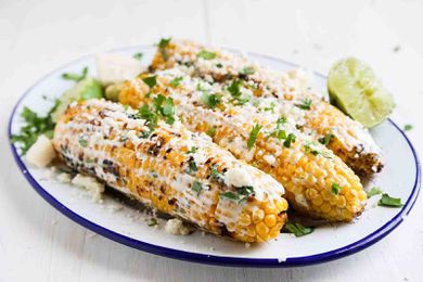 Mexican Street Corn topped with crema and cilantro on a plate