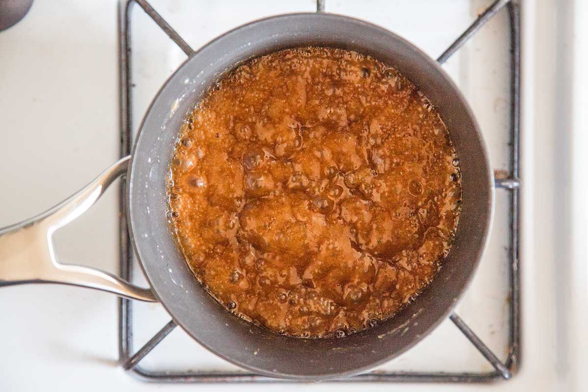 Brown sugar, butter, and salt cooking in a pot on a stove