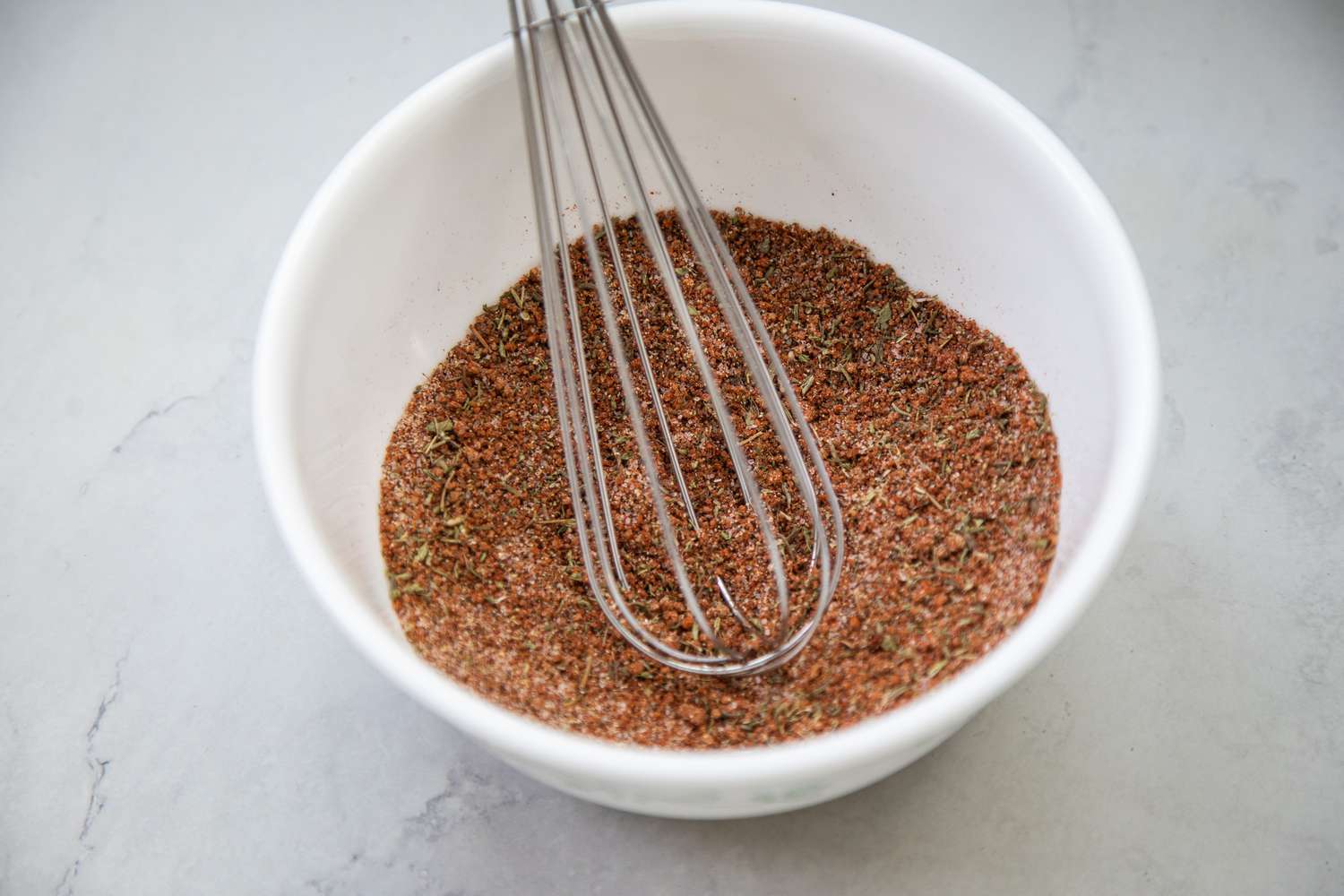 Bowl of Spices and a Whisk for Pork Chop Seasoning Recipe