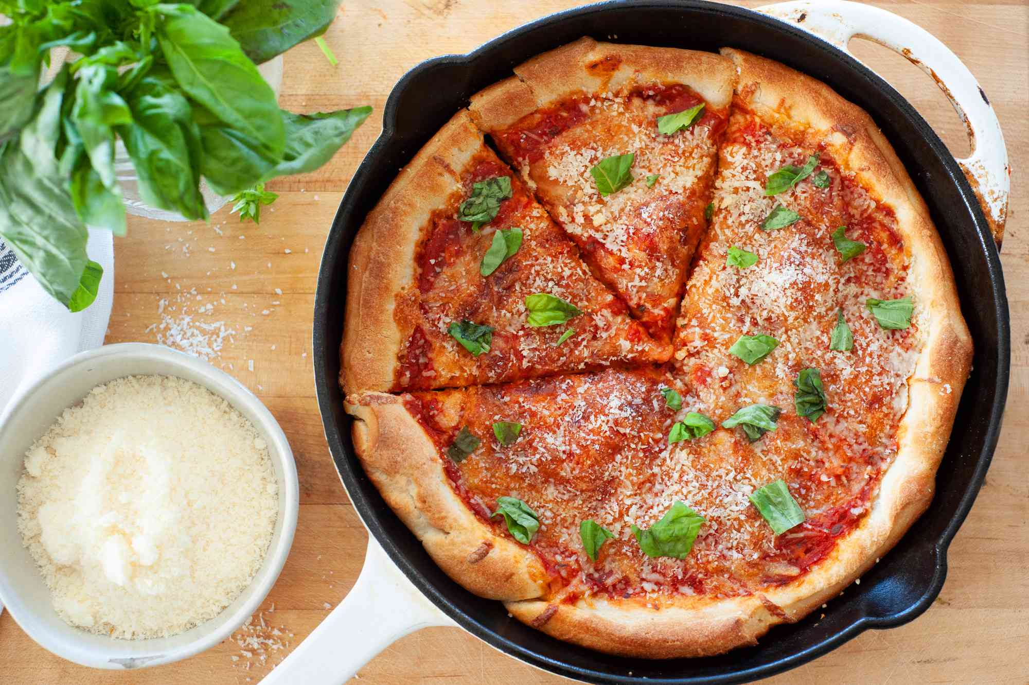 Cast iron pizza with parmesan and basil.