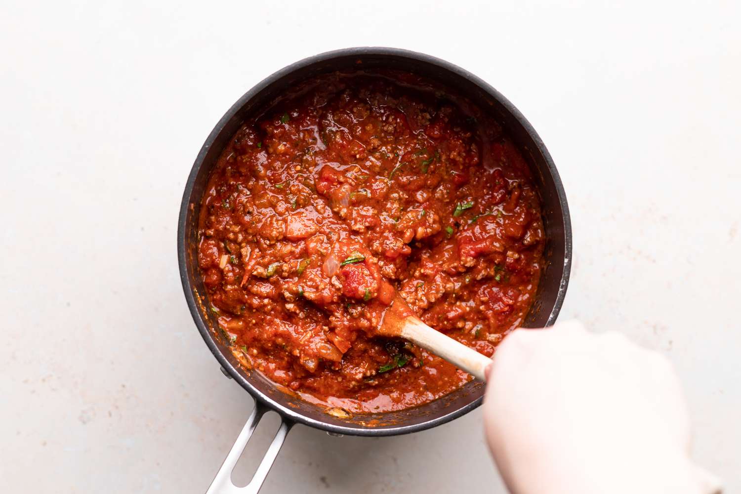 Making an easy lasagna recipe and stirring the sauce in a pan.