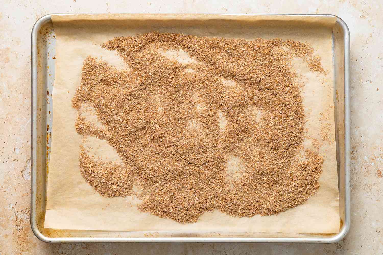 Oven toasted wheat bran on a parchment paper lined baking tray for bran muffins recipe