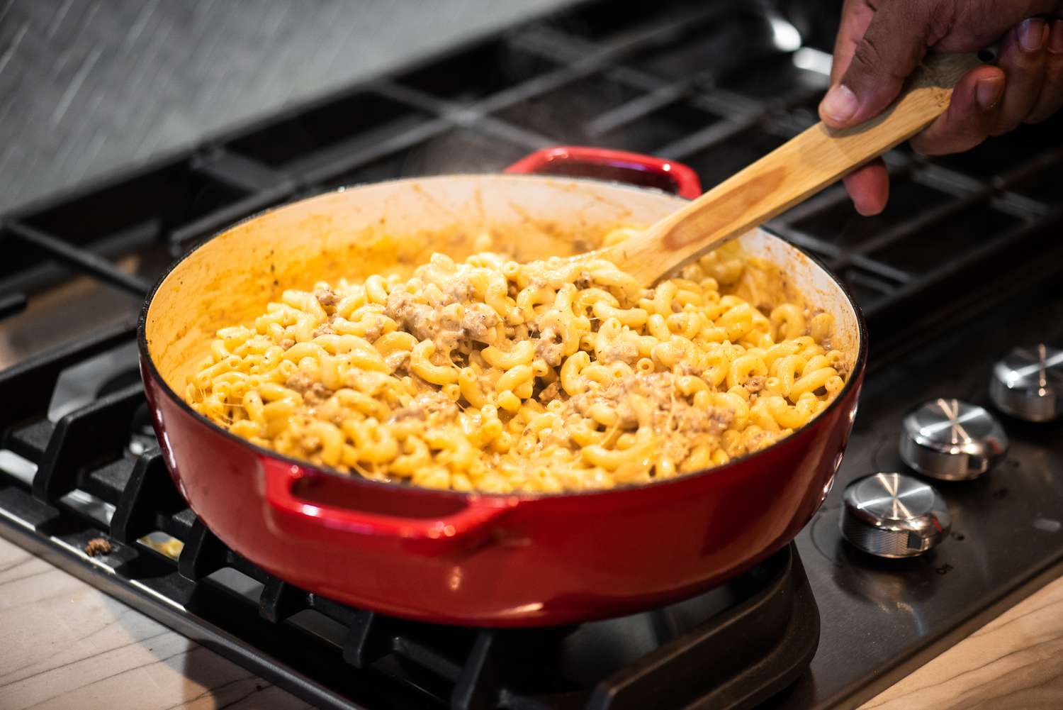 Cheeseburger Casserole Ingredients Mixed Together in a Dutch Oven over a Stove