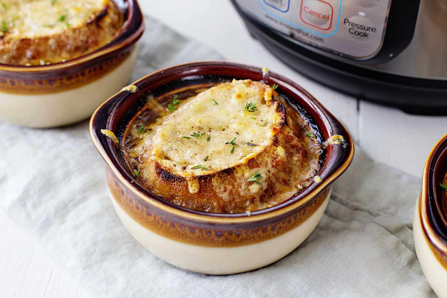 A bowl of French onion soup with a cheesy crouton ready to eat.