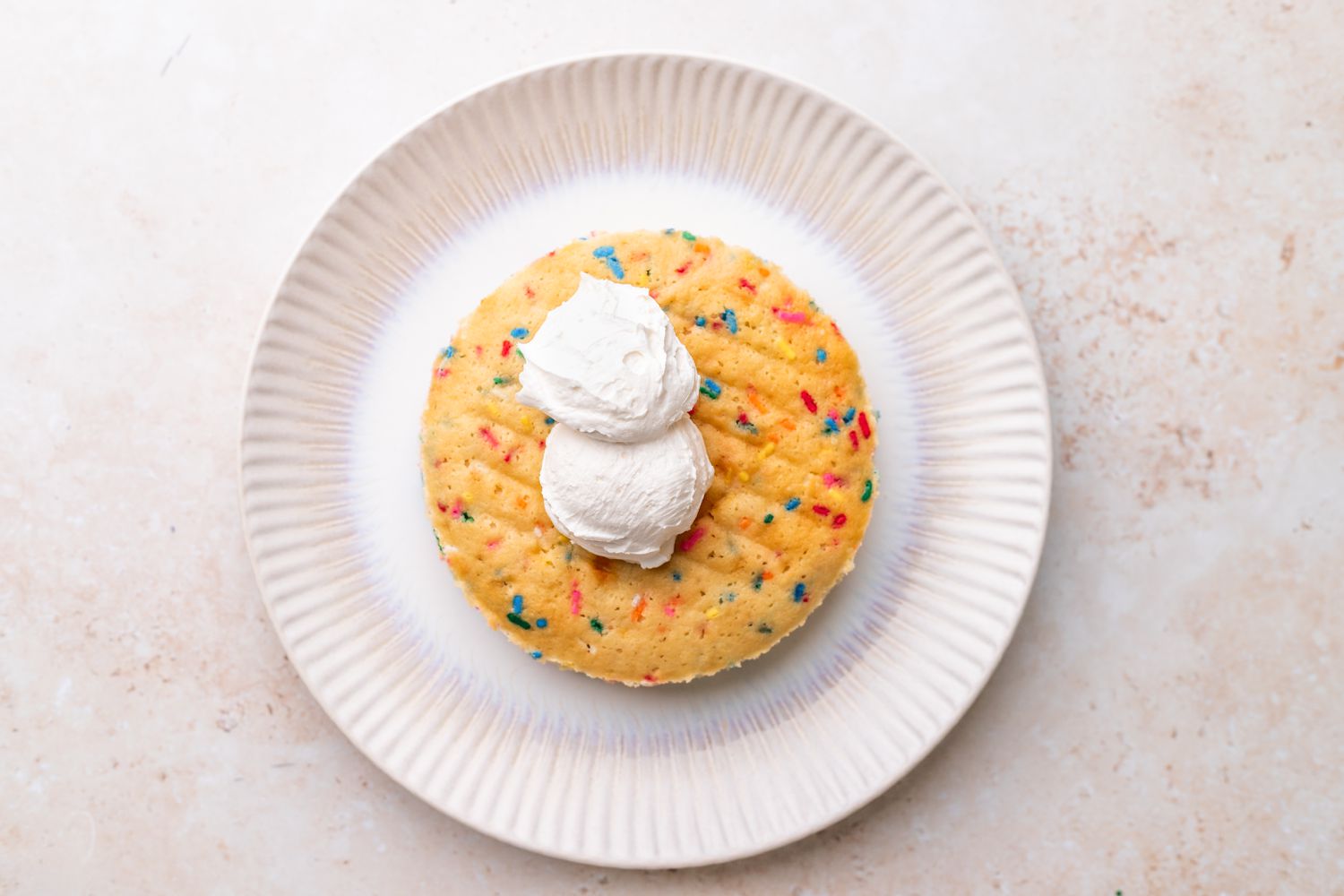 Frosting Added to a Layer of Unicorn Cake on a Plate 