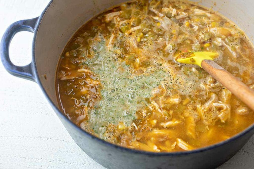Hatch chili soup made on the stove in a blue Dutch oven
