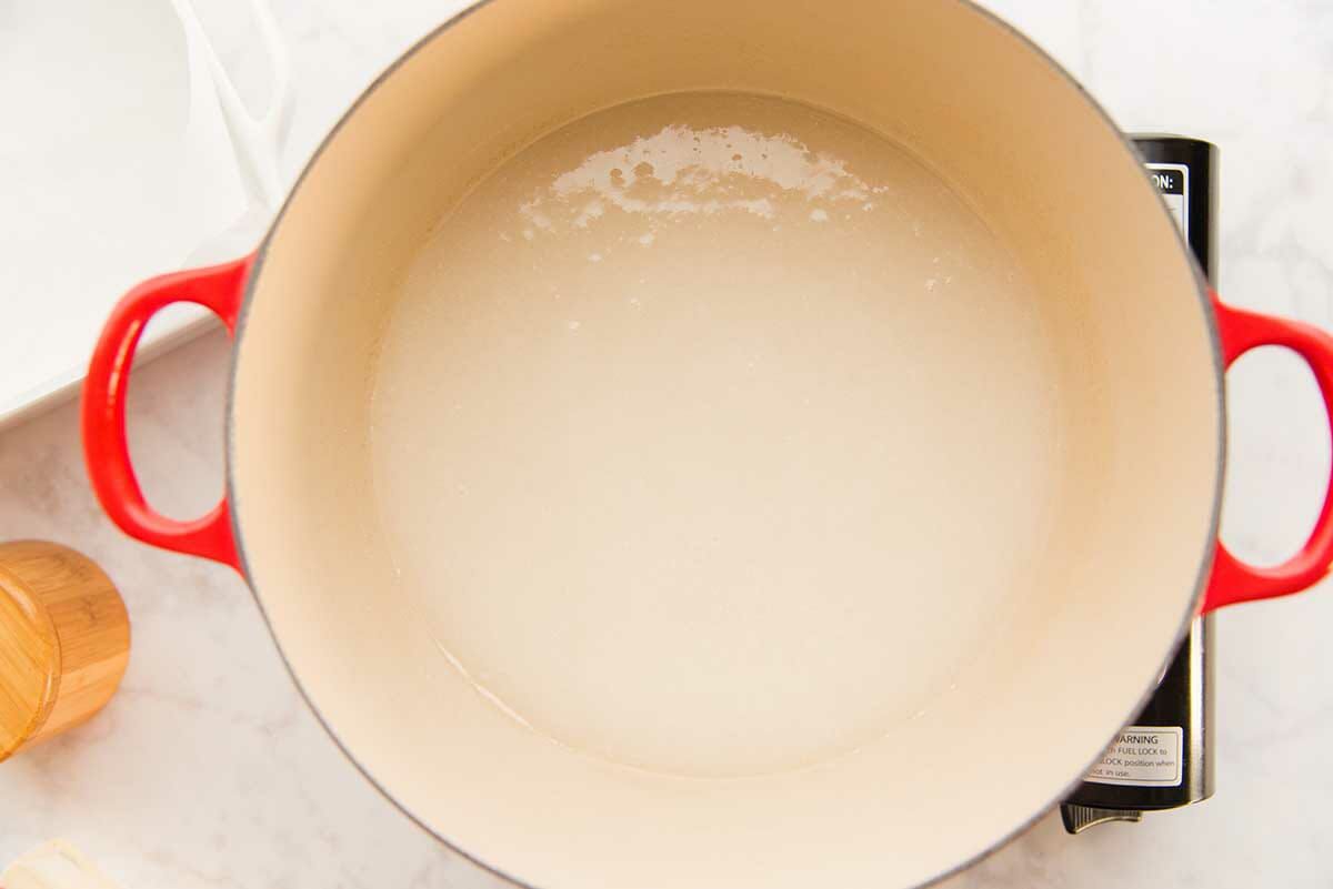 Water and sugar in a dutch oven to show how to make soft and chewy caramels.