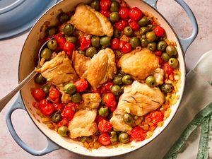 Overhead view of tuscan-style chicken thighs in a blue dutch oven of 