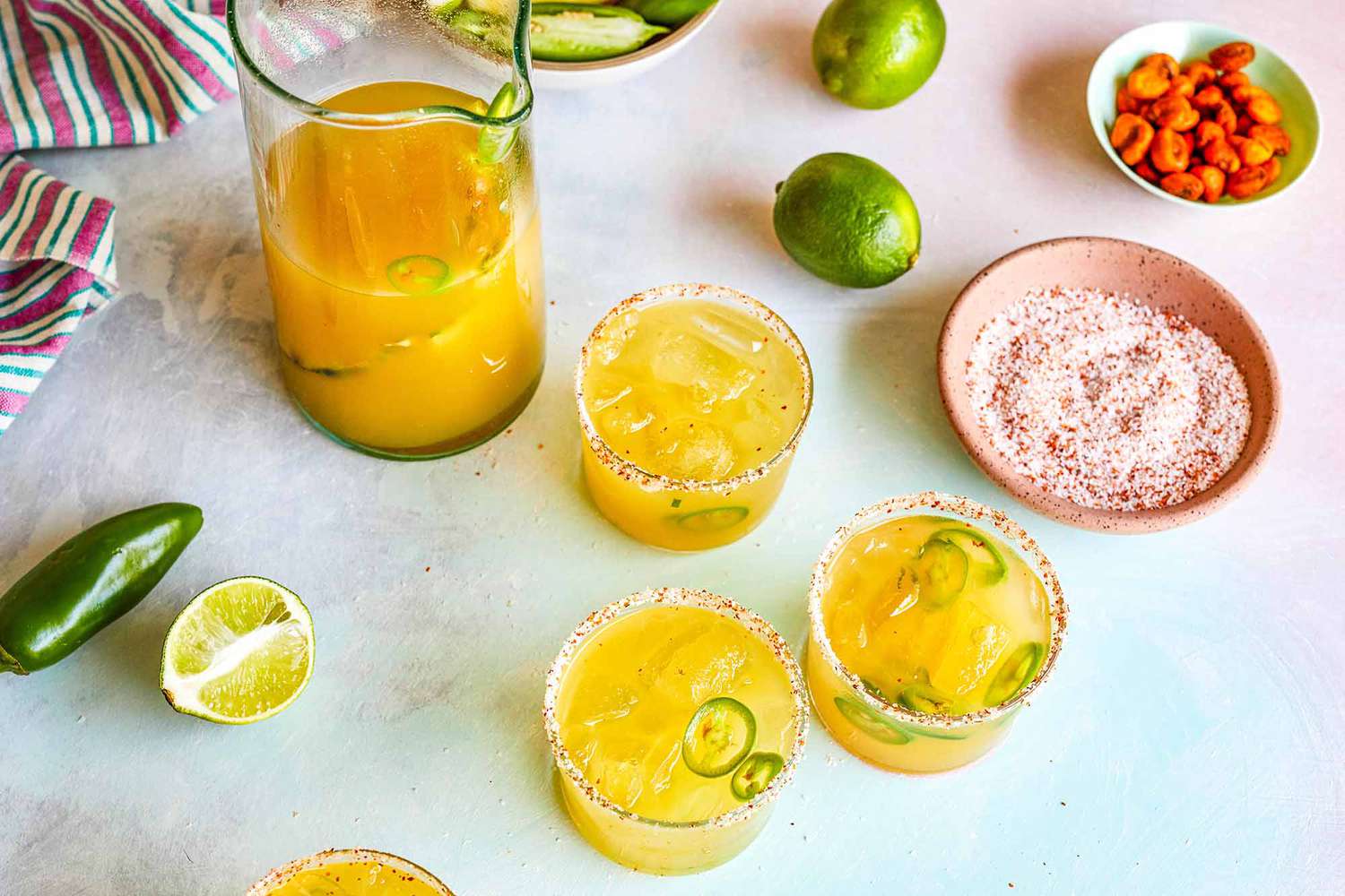 Pineapple Margaritas in a pitcher and poured into three glasses with garnishes