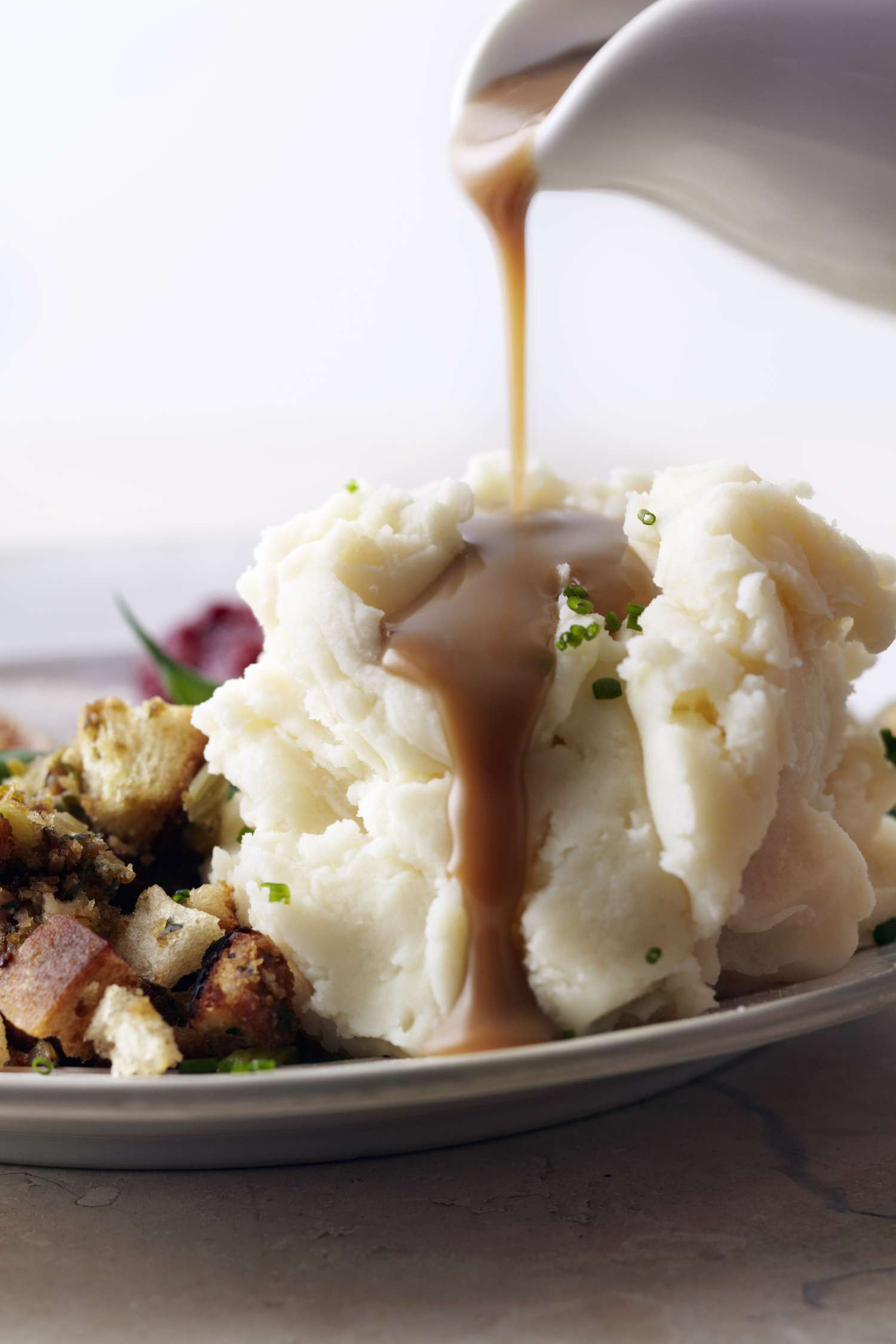 Gravy being poured over mashed potatoes