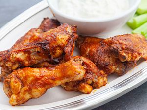 Close up of buffalo wings recipe with blue cheese dressing and celery.